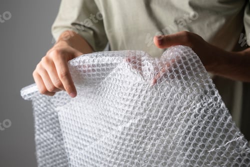 Preview: a person holding and bursting bubble protective wrap trying to calm down