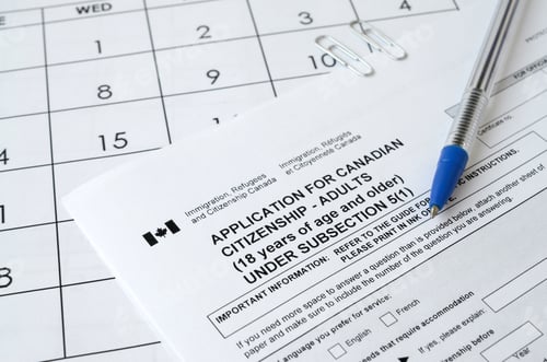 Preview: Application for Canadian citizenship for adults and blue pen lies on calendar page close up