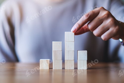 Preview: Closeup image of a hand stacking and picking blank wooden cube block