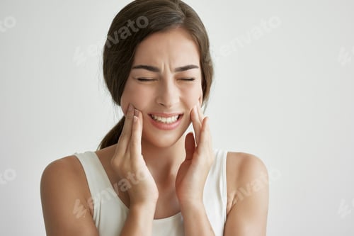 Preview: woman in white t-shirt holding face toothache discontent close up