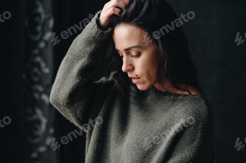 Preview: Pensive Woman in Gray Sweater Looking Down