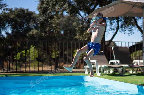 Preview: Child diving into swimming pool on sunny summer day