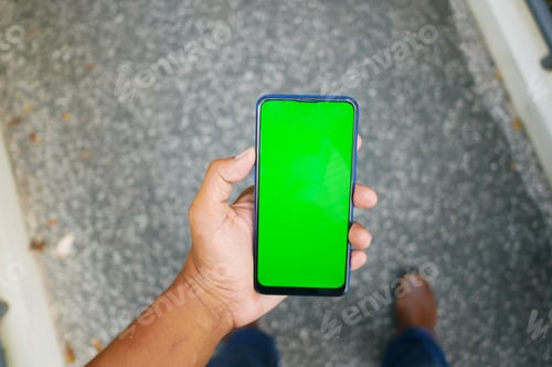 Preview: POV of young man hand using smart phone with green screen