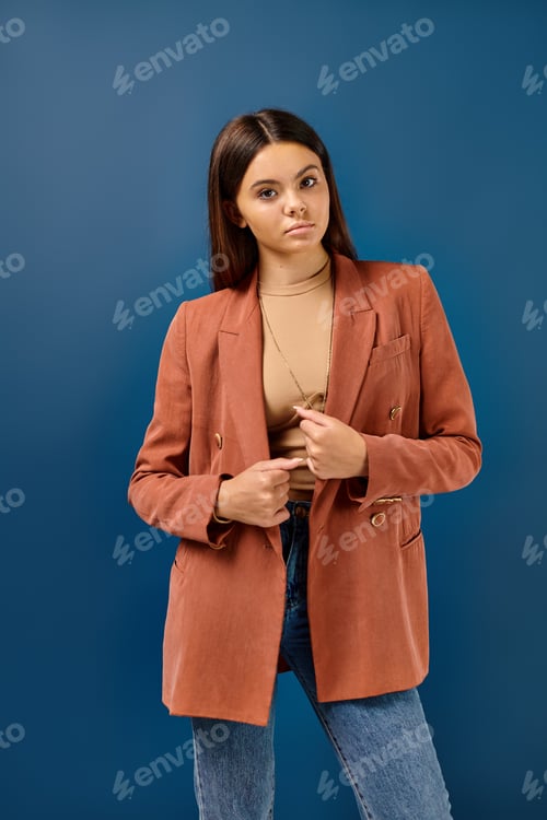 Preview: good looking stylish teenage girl in elegant brown blazer posing and looking straight at camera