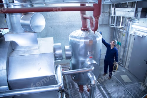 Preview: Elevated view of engineer inspecting machinery in power station