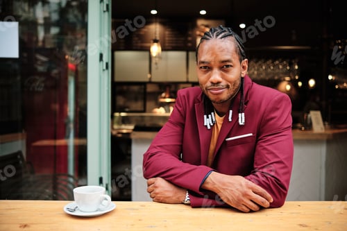 Preview: Portrait of a stylish african man sitting in a cafeteria
