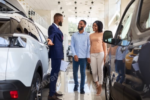 Preview: Car Salesman Helping Black Spouses To Choose New Automobile In Dealership Center