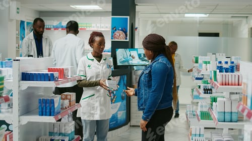 Preview: Drugstore worker helping client with pharmaceutics