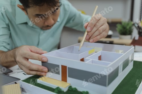 Preview: Asian male architect is analyzing a modern house model