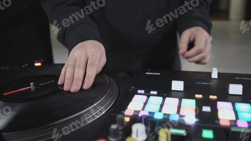 Preview: DJ spinning record at disco. Art. Close-up of DJ's hand on mixer. Glowing music panel at party