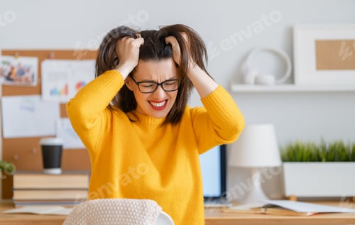 Preview: Young woman studying and having a head ache
