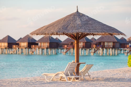 Preview: White lounge chairs on a beautiful tropical beach at Maldives