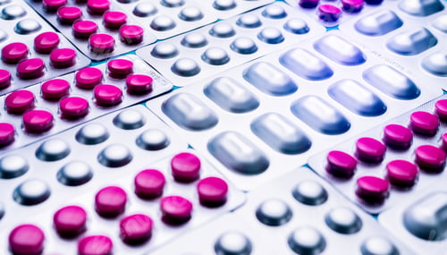 Preview: Pink tablets piils in blister pack and silver aluminium foil pack of pills. Pharmaceutical industry.