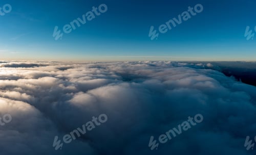 Preview: Thick layer of white clouds above mountains at sunrise