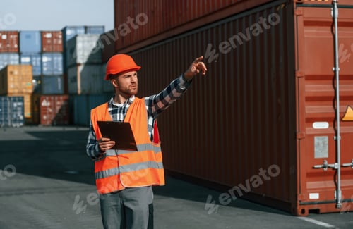 Preview: Giving instructions by the hand. Male worker is on the location with containers