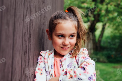 Preview: Portrait of smiling girl leaning against wooden wall