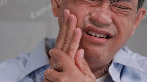Preview: Asian senior man suffering from toothache.