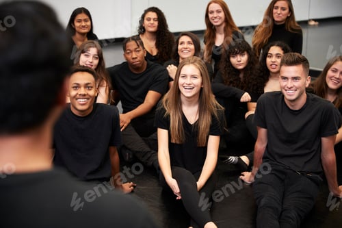Preview: Teacher At Performing Arts School Talking To Students Sitting On Floor In Rehearsal Studio