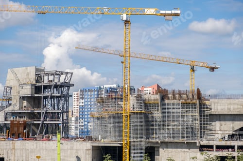 Preview: crane and a building under construction against a blue sky background