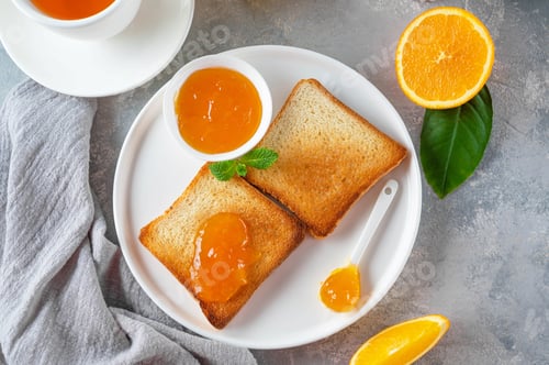 Preview: Bread toasts with homemade orange jam on a white plate on a gray concrete background