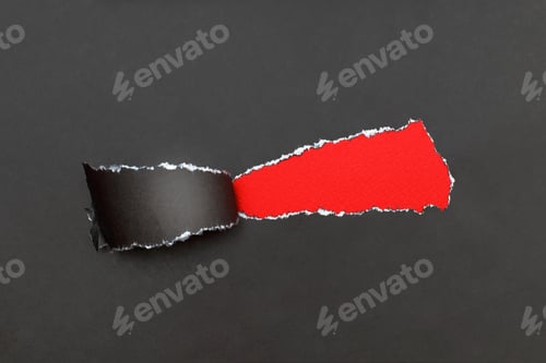 Preview: curl of torn black paper on red background. advertising and sale concept. copy space