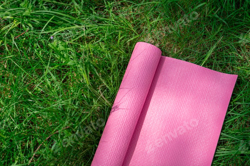 Preview: Pink yoga mat on fresh green grass. Equipment for yoga. Concept healthy lifestyle, sport