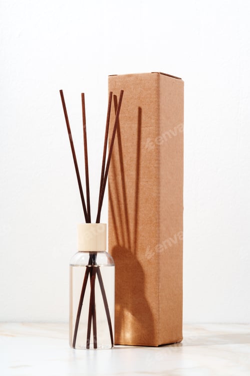Preview: Reed Diffuser Bottle and Cardboard Box on White Marble Surface