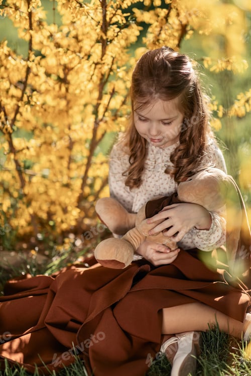 Preview: portrait of a little girl in retro-style clothes on a green lawn in a city park