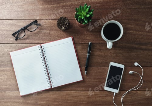 Preview: Blank notebook and cup of coffee on wooden desk
