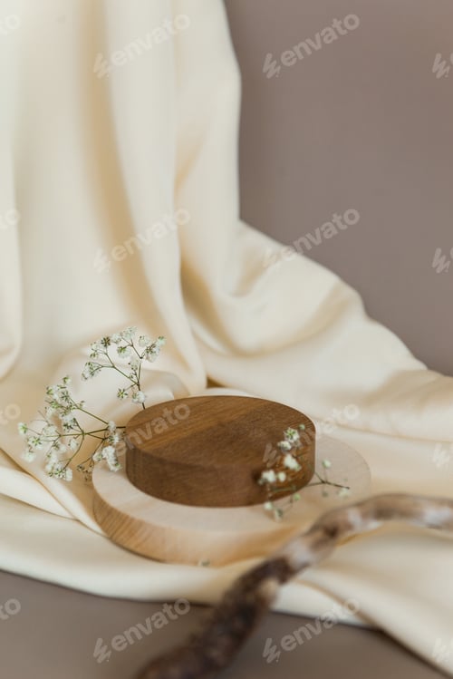 Preview: Empty wooden podium gray background. Product presentation with flowers, silk cloth and leaves