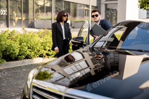 Preview: Female chauffeur helps a businessman to get out of the car