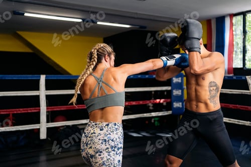 Preview: Young adult man and woman training box on the ring