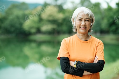 Preview: Happy athletic Senior woman checking her smartwatch in the park.