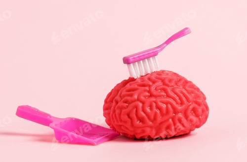Preview: Model of human brain with brush and dustpan on pink background. Brain detox concept.