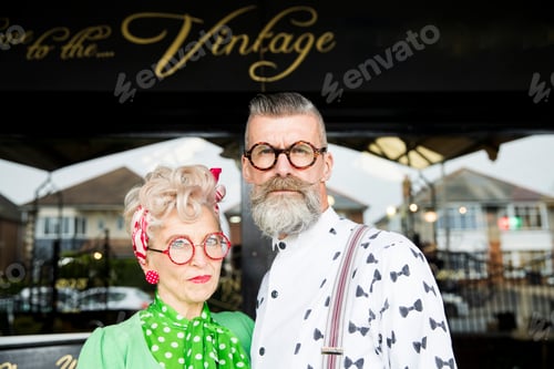 Preview: Serious portrait of a quirky vintage couple outside vintage shop