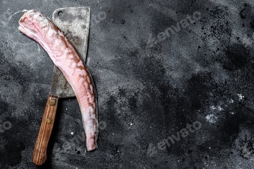 Preview: Raw king klip, congrio fish on a cleaver. Black background. Top view. Copy space
