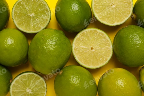 Preview: Fresh ripe lime on yellow background, top view