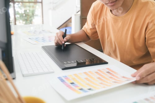 Preview: Young photographer and graphic designer at work in office.