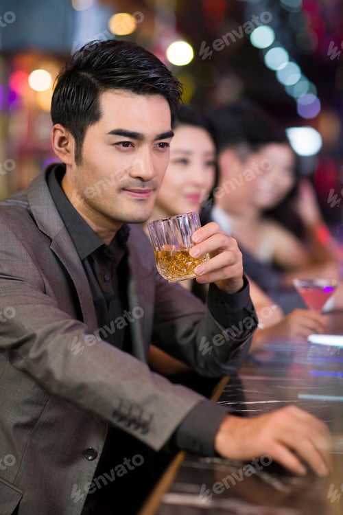 Preview: Young man drinking alcohol in bar