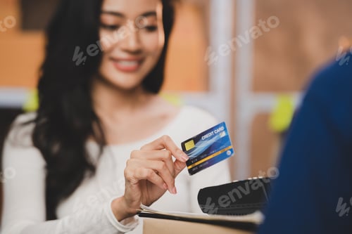 Preview: credit card wireless POS terminal payment concept, girl received a parcel from a male delivery man