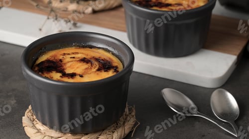 Preview: Three ramekins of creamy custard with a caramelized sugar crust, on a rustic wooden table