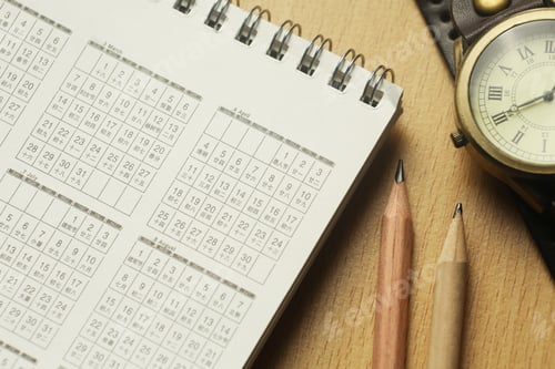Preview: Close-Up of Japanese Desk Calendar with Vintage Watch and Pencils