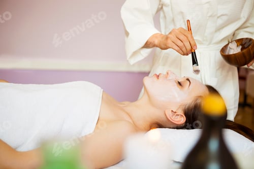 Preview: Young woman in a mask for the face of the therapeutic white mud. Spa treatment