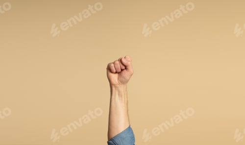 Preview: A man's hand, showing his fist, on a beige background. Feminist Movement.