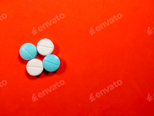 Preview: A white and blue medicine pills on red background