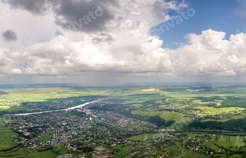 Preview: Bright landscape of white puffy cumulus clouds on blue clear sky over rural area.