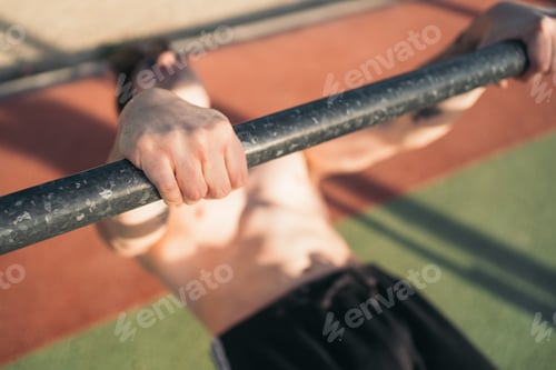 Preview: Enthusiast calisthenic man performing front lever outdoors.