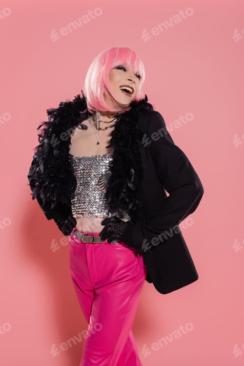 Preview: Carefree transgender person in jacket with feathers posing on pink background
