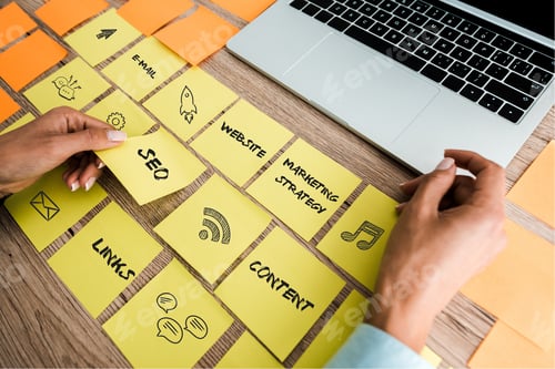 Preview: cropped view of woman touching sticky note with seo lettering near laptop on desk