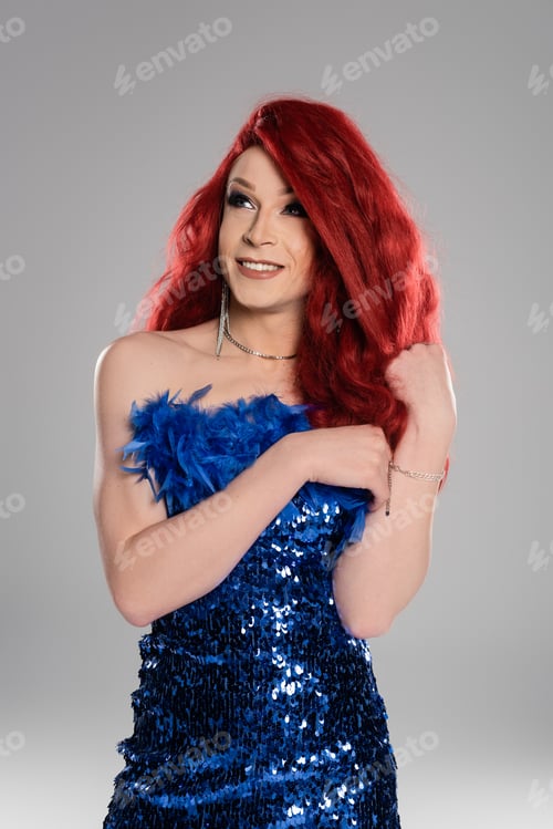 Preview: Portrait of carefree man with makeup in dress looking away isolated on grey